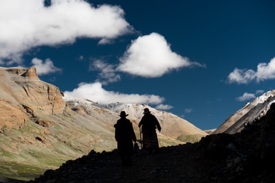 两人站在山的顶部在蓝天和白云白天
